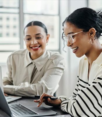 a group of people looking at a laptop
